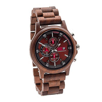 A wooden watch with a walnut band and a red dial with chronograph features.